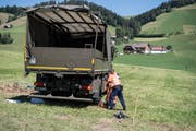 Zwei Polizisten untersuchen den verunfallten Lastwagen der Armee (Bild: Peter Schneider / Keystone)