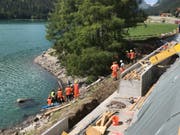 Der abgestürzte Bagger ist fast ganz im See verschwunden. Beim Unfall verletzte sich der Maschinist schwer. (Bild: Kapo GR)