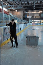 Eismeister und Anlagewart Erwin Mettler schaufelt noch das letzte Eis vom Feld. (Bild: Miranda Diggelmann)
