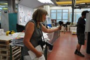 Multimediales Handwerk der Journalistin: Karin Erni erstellt mit dem Handy samt Mikrofon einen Film für online, schiesst mit der Kamera Fotos für die Zeitung und hält auf dem Block Denkwürdiges für den Artikel fest. (Bild: EG)