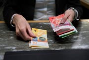 An einem Bankschalter wird Geld gezählt. (Corinne Glanzmann, Luzern, 18. Januar 2018)