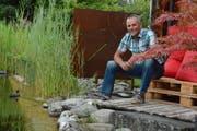 Natürlicher Schwimmteich statt betonierter Pool: Paul Stahlberg, Gemeinderat und Präsident der Nachhaltigkeitskommission, im Garten seines Hauses in Schönenberg. (Bild: Georg Stelzner)
