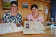 Die amtierende Aktuarin Annelies Jud (links) und die Präsidentin Ursi Jäger mit den historischen, handschriftlich geführten Protokollbüchern des Vereins. (Bild: Adi Lippuner)