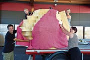 Daniel Schmid, Brigitte König, Antje Haffter und Chantal Hebeisen bekleiden Burninas Torso mit dem BH. (Bild: Mario Testa)