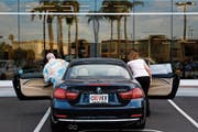 Ein amerikanische Paar steigt zur Probefahrt in ein Modell des deutschen Herstellers BMW. (Bild: Patrick T. Fallon/Bloomberg (Santa Ana, 2. Juni 2014))