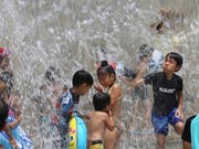 Kinder kühlen sich in einem Park in Tokio ab. (Bild: KEYSTONE/AP/KOJI SASAHARA)