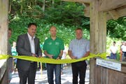 Hansjörg Huser, Hanspeter Wohlwend und Kilian Looser (von links) durchschneiden bei der Eröffnung das Band. (Bild: Adi Lippuner)