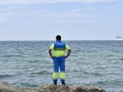 Können einem den Badespass schnell einmal verderben: Ein Helfer hält am Strand El Molinar in Palma des Mallorca Ausschau nach Portugiesischen Galeeren. (Bild: KEYSTONE/EPA EFE/ATIENZA)