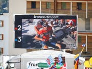 Zuschauer im Ziel verfolgen auf einem TV-Bildschirm, wie Vincenzo Nibali nach seinem Sturz im Anstieg zur Alpe d'Huez mit grossen Schmerzen am Boden sitzt (Bild: KEYSTONE/EPA/KIM LUDBROOK)