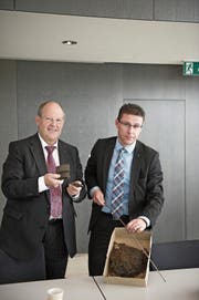 Stadtrat Fredy Brunner und Projektleiter Marco Huwiler zeigen Trümmerstücke aus dem Bohrloch. (Bild: Urs Jaudas, 27. September 2013)