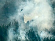 Wie ein Tropfen auf einen heissen Stein: Ein Löschhelikopter wirft über einem Waldbrand bei Ljusdal Wasser ab. (Bild: KEYSTONE/EPA TT NEWS AGENCY/MAJA SUSLIN)