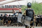 Polizisten halten in Basra Demonstranten von zentralen Regierungsgebäuden fern. (Bild: AP; 15. Juli 2018)