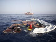Überreste eines Flüchtlingsboots im Mittelmeer vor der Küste Libyens: Im Wasser treiben auch zwei Leichen. (Bild: KEYSTONE/AP)