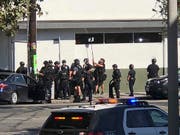 Polizisten versuchen mit einem Spiegel einen Blick ins Innere des Supermarkts zu erhalten. (Bild: KEYSTONE/AP Christian Dunlop)