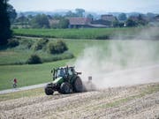 Es wird auch nächste Woche Staubwolken geben, wenn Landwirte mit ihren Traktoren über die Felder fahren. Am Montag beginnen die Hundstage und der Regen vom Wochenende brachte kaum Besserung für die trockenen Böden. (Bild: KEYSTONE/URS FLUEELER)