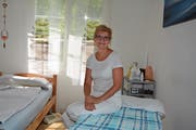 Irene Geiger sitzt auf ihrem Massagetisch, den sie bald in die Ecke stellen wird. (Bild: Beat Lanzendorfer)