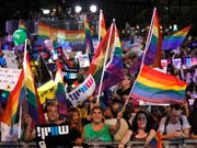 In Israel sind am Sonntag Tausende mit Regenbogenfahnen auf die Strasse gegangen, um gegen ein neues Gesetz zu protestieren. (Bild: KEYSTONE/EPA/ABIR SULTAN)