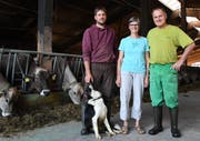 Reto, Gaby und Werner Eigenmann stehen mit ihrem Hofhund, dem Border Collie Odine, in der Scheune bei den Kühen. (Bild: Yvonne Aldrovandi-Schläpfer)