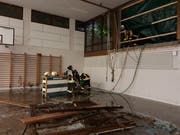 Feuerwehrleute pumpen Wasser aus der überfluteten Turnhalle der Schulanlage Reutenen.