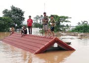 Bewohner retten sich auf ihre Hausdächer, nachdem das ausgetretene Wasser mehrere Dörfer geflutet hat. (Bild: ABC Laos News / EPA, 24. Juli 2018)
