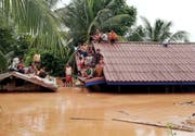 Dorfbewohner in Laos warten auf einem Hausdach auf ihre Rettung. (Bild: EPA/ABC LAOS NEWS, 24. Juli 2018)