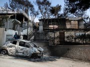 Das Drama im Osten Athens um die Hafenstadt Rafina geht weiter. Freiwillige Helfer und die Feuerwehr entdecken immer wieder neue Opfer in den verbrannten Häusern des ehemaligen Ferienparadieses. (Bild: Keystone/AP/THANASSIS STAVRAKIS)