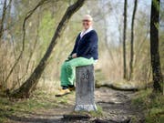 Berta Thurnherr-Spirig, Geschichtensammlerin und Mundartwortspielerin, sitzt im April 2018 auf einem Grenzstein am Alten Rhein in Diepoldsau SG. (Bild: Keystone/GIAN EHRENZELLER)
