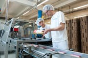 Mitarbeiter der Hochdorf-Gruppe beim Abpacken eines Produktes für den chinesischen Markt. (Archivbild: Dominik Wunderli, 10. April 2012)