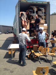 Die Helfer beladen einen Schiffscontainer mit Schulmobiliar. (Bild: Anita Fahrni)