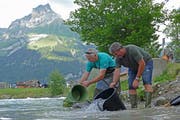 Wildhüter Klaus Hurschler (rechts) und Winfried König von der Forellenfarm Luterbach in Ennetmoos setzen Bach- und Regenbogenforellen aus. (Bild: Beat Christen (Engelberg, 16. Juli 2018))