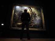 Ein Besucher vor Eugène Delacroix' Gemälde «La liberté guidant le peuple». Die Schau bescherte dem Louvre einen Rekord: In vier Monaten wurden 540'000 Eintritte gezählt. (Archivbild März 2018) (Bild: Keystone/EPA/ETIENNE LAURENT)
