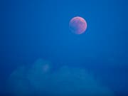 Der in rotem Licht erscheinende Mond von Luzern aus gesehen. (Bild: KEYSTONE/URS FLUEELER)