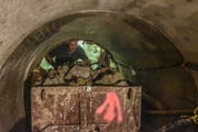 Einer der Bauarbeiter schaufelt im hintersten Teil des Tunnels Lehm in einen Wagen. Das Material hat er zuvor mit einem Handkompressor abgebaut. (Bilder: Roman Scherrer)