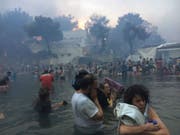 In der Kleinstadt Nea Makri im Osten des griechischen Festlands flüchteten zahlreiche Menschen vor den Flammen ins Meer. (Bild: KEYSTONE/AP Elia Kallia)