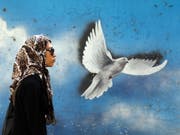 Irans Frauen wollen keinen Kopftuchzwang mehr: Frau vor einem Wandgemälde in Teheran. (Bild: KEYSTONE/EPA/ABEDIN TAHERKENAREH)