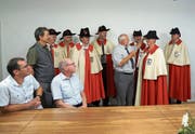 Giswils alt Gemeindeweibel Hanspeter Schnider übergibt seiner Nachfolgerin Esther Windlin-Berchtold die Amtstracht. Die Weibel aller Obwaldner Gemeinden sind mit dabei. (Bild: Romano Cuonz (Giswil, 2. Juli 2018))