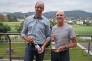 Markus Gabathuler vom Büelsteihof in Oberschan (links) und Hans Zogg, Zogg Mosterei-Brennerei AG, Grabserberg, präsentieren stolz je eines ihrer hre prämierten Produkte. (Bild: PD)
