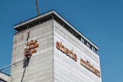 Von einem Hängekorb aus werden das Mühlrad-Symbol und der Schriftzug «eberle mühlen» in rund 50 Metern Höhe abmoniert. Der Pneukran befindet sich auf der anderen Seite der Mühle. (Bild: Hans Suter)
