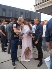 Beim Apéro begutachtet Automobil-Mechatronikerin Nina Stieger mit ihrem Freund Simon Ammann (links) und ihrem Berufskollegen Adrien Carrel (rechts) ihr Zeugnis. (Bild: Angelina Donati)