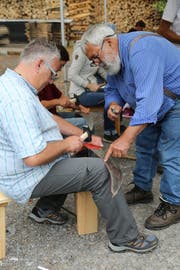 Hansjörg von Känel (r.) zeigt einem Kursteilnehmer wie man richtig «dengelt». (Bild: Martin Rechsteiner)