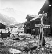 Beschädigte Häuser, Trümmer und Warnschilder vor Blindgängern nach den Explosionen im Munitionsstollen. (KEYSTONE/PHOTOPRESS-ARCHIV/Walter Studer)