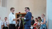 Maturand Basil Schnellmann empfängt die Rose von Prorektor Johannes Horschik. (Bild: PD)