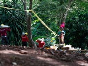 Rettungskräfte mit Sauerstoffflaschen am Donnerstag vor der Höhle - vor der sich reges Leben entfaltet hat. (Bild: Keystone/EPA/RUNGROJ YONGRIT)
