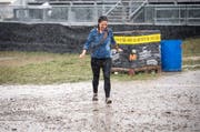 Eine Besucherin kämpft sich durch Regen und Schlamm.