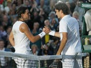Ein Bild für die Ewigkeit: Auf dem schon sehr dunklen Centre Court von Wimbledon gratuliert Roger Federer (re.) Rafael Nadal zum Sieg (Bild: KEYSTONE/AP/ANJA NIEDRINGHAUS)