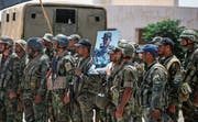 Syrische Soldaten halten ein Bild Baschar al-Assads in die Höhe. (Bild: Youssef Karwashan/AFP (Daraa, 7. Juli 2018))