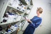 Apothekerin Claudia Held, Inhaberin der Rathausapotheke, ordnet im Untergeschoss Chemikalien ins Regal, die sie für ihre unterschiedlichsten Rezepturen benötigt. (Bilder: Andrea Stalder)