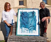 Karin Noser und Armin Nüesch mit dem Kunstdruck, der auf der Bank abgelegt worden war. Bild: acp