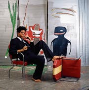 Der Künstler und seine Werke: Jean-Michel Basquiat auf einer Aufnahme aus dem Jahr 1985. (Bild: Lizzy Himmel/Brooklyn Museum/AP)