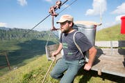 Alp Oberalp in Isenthal: Ferdi Ziegler lädt die Brennnte auf die Seilbahn. (Bild: Christof Hirtler, Isenthal, 25. Juli 2018)